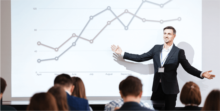Smiling charismatic speaker giving public presentation in conference hall