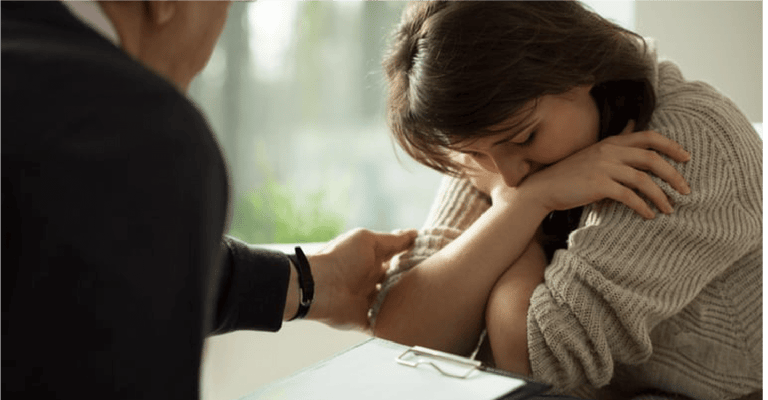 Close-up of psychologist comforting his depressed patient