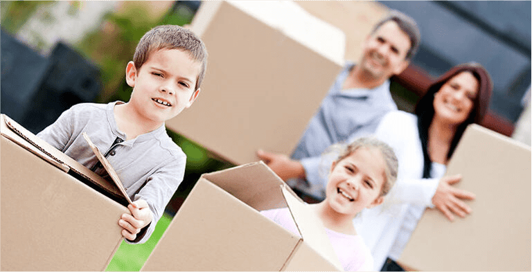 Family moving home and carrying cardboard boxes
