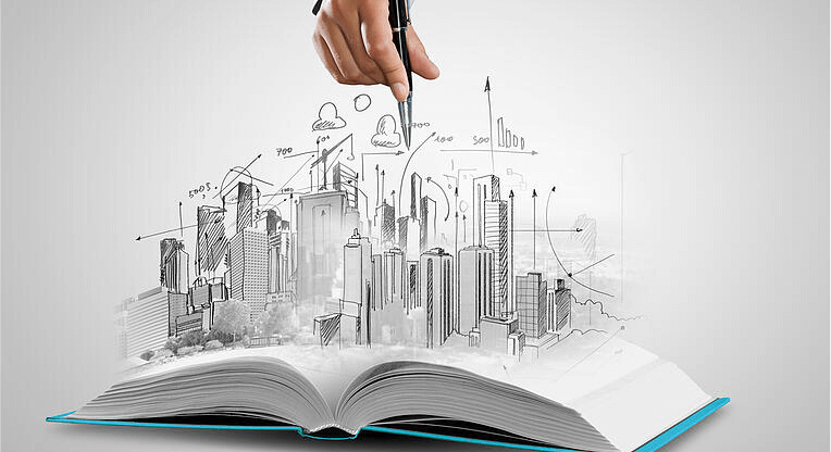 Opened book and hand drawing building sketches