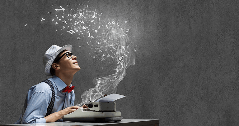 Young funny man in glasses writing on typewriter