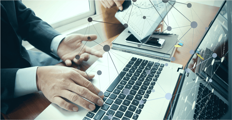 business documents on office table with smart phone and digital tablet and stylus and two colleagues discussing data in the background