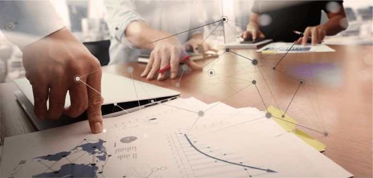 business documents on office table with smart phone and laptop computer and graph financial with social network diagram and two colleagues discussing data in the b
