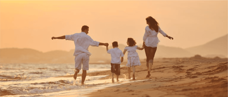 happy young family have fun on beach run and jump  at sunset